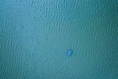 Deniz ve okyanus yüzeyinin turkuaz renkli sularının üzerindeki dron 'dan gelen güzel deniz manzaralı tekne ya da gemi, kopyalama uzayı. Üst görünüm.