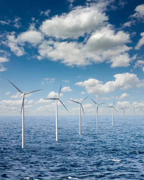 コピースペースの広い海の上の青い曇り空を背景に風力タービンによる再生可能エネルギーの生態学的生産 生態学的代替エネルギー概念 — ストック写真