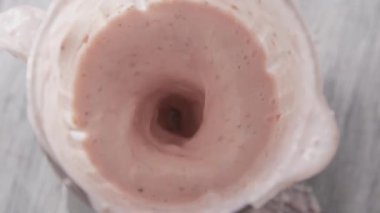 Çilek, süt ve cam kasedeki chia tohumlarından taze ev yapımı milkshake. 