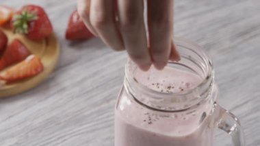 Bardaktaki organik sütlü çilekli smoothie. Sağlıklı tatlı.