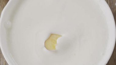  Dilimlenmiş şeftali kaseye süt ve video ile düşüyor. 