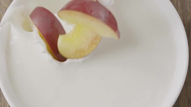切好的桃和牛奶一起掉进碗里 — 图库视频影像