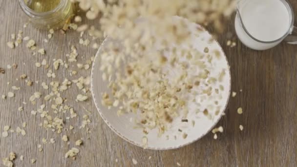 オートミールグラノーラは皿に落ちる ビーガン有機食品の食事の概念 — ストック動画