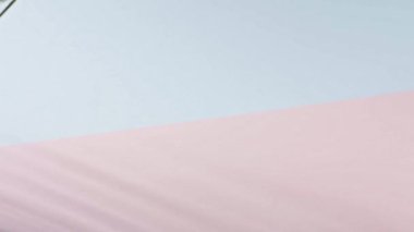 Pembe ve mavi arkaplanda hareket eden palmiye dalı, kopyalama alanı. Tropik yeşil yapraklar