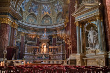 Macaristan, Budapeşte 'de duvarlarında renkli resimler, mermer heykeller ve heykeller olan Katolik Katedrali' nin harika bir iç mekanı..
