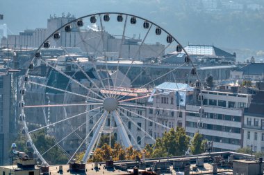 Macaristan 'ın Budapeşte şehrinin eski tarihi kısmının arka planında büyük yuvarlak dönme dolap eğlencesi, Budapeşte Gözü.