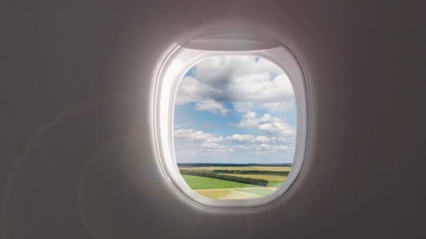 Grüner Rasen Und Wolkenverhangener Himmel Durch Den Fensterrahmen Des Flugzeugs — Stockvideo