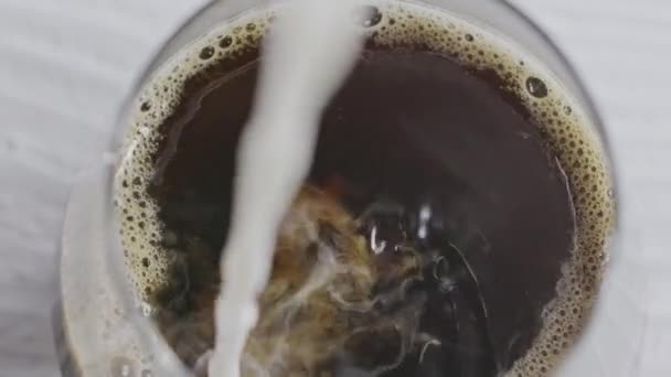 咖啡加牛奶 牛奶倒入一杯咖啡中 — 图库视频影像