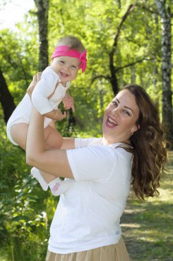 Mutlu bir aile. Küçük kızı annesiyle parkta oynamak