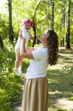 Mutlu bir aile. Küçük kızı annesiyle parkta oynamak