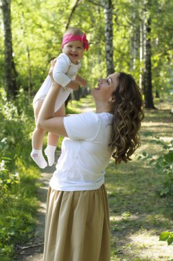 Mutlu bir aile. Küçük kızı annesiyle parkta oynamak