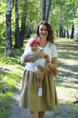 Mutlu bir aile. Parkta küçük kızı yürüyüş ile anne