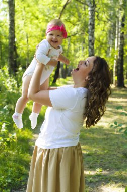 Mutlu bir aile. Küçük kızı annesiyle parkta oynamak