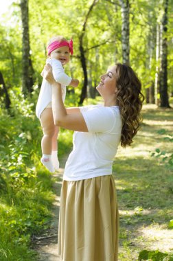 Mutlu bir aile. Küçük kızı annesiyle parkta oynamak