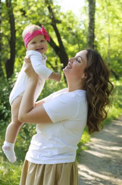 Mutlu bir aile. Küçük kızı annesiyle parkta oynamak