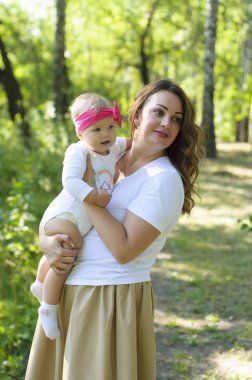 Mutlu bir aile. Küçük kızı annesiyle parkta oynamak