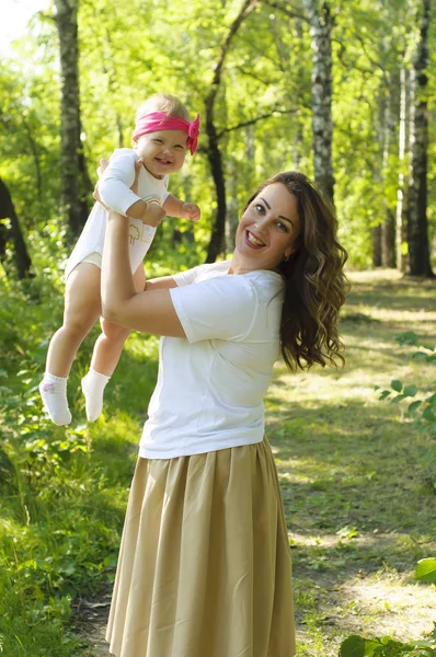 Mutlu bir aile. Küçük kızı annesiyle parkta oynamak