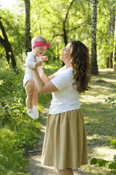 Mutlu bir aile. Küçük kızı annesiyle parkta oynamak