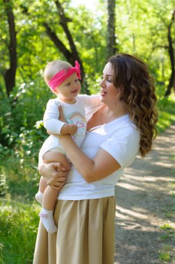 Mutlu bir aile. Küçük kızı annesiyle parkta oynamak