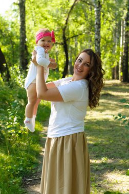 Mutlu bir aile. Küçük kızı annesiyle parkta oynamak