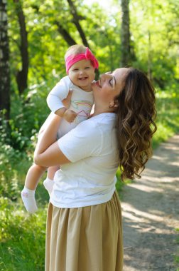 Mutlu bir aile. Küçük kızı annesiyle parkta oynamak