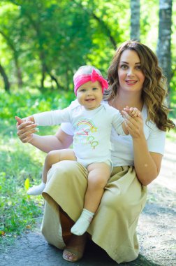 Mutlu bir aile. Küçük kızı annesiyle parkta oynamak