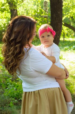 Mutlu bir aile. Küçük kızı annesiyle parkta oynamak