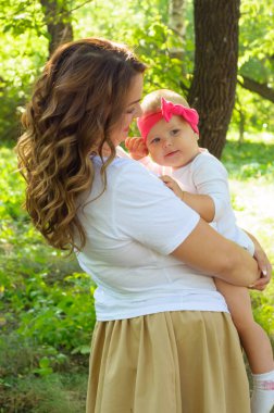 Mutlu bir aile. Küçük kızı annesiyle parkta oynamak