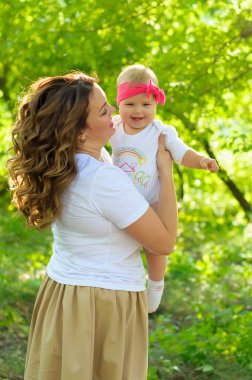 Mutlu bir aile. Küçük kızı annesiyle parkta oynamak