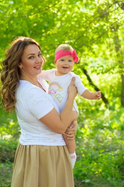 Mutlu bir aile. Küçük kızı annesiyle parkta oynamak