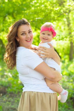 Mutlu bir aile. Küçük kızı annesiyle parkta oynamak