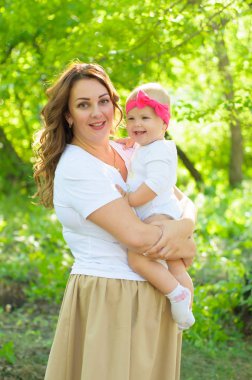 Mutlu bir aile. Küçük kızı annesiyle parkta oynamak