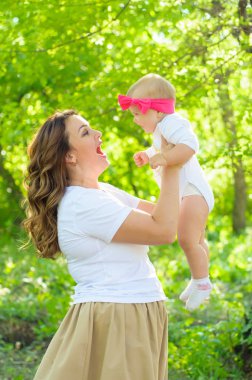 Mutlu bir aile. Küçük kızı annesiyle parkta oynamak