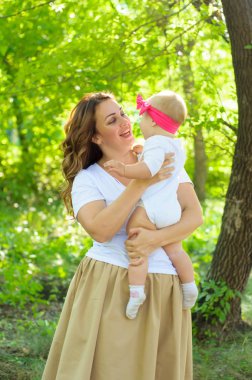 Mutlu bir aile. Küçük kızı annesiyle parkta oynamak