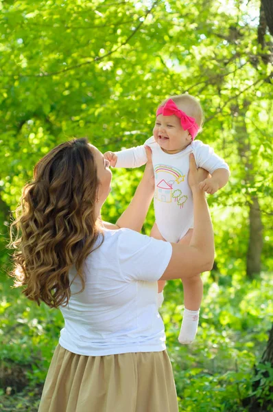Mutlu bir aile. Küçük kızı annesiyle parkta oynamak