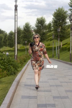 Kamera ve paketleme pizza kadınla sokakta yürüyor