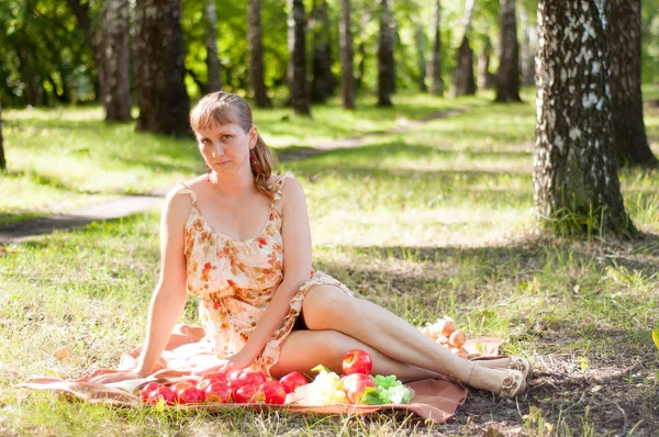 The Russian woman has a rest on a picnic in the wood in the summ