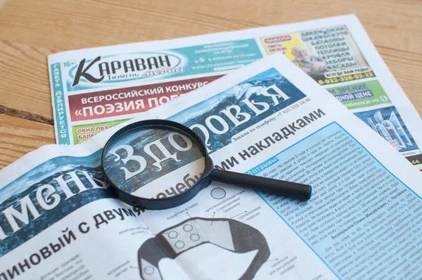 Martwa żywotność: Rosyjskie gazety i szkło powiększające. — Zdjęcie stockowe