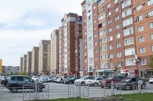 Tyumen, Russia, on May 8, 2019: Inhabited brick high houses stand in a row.