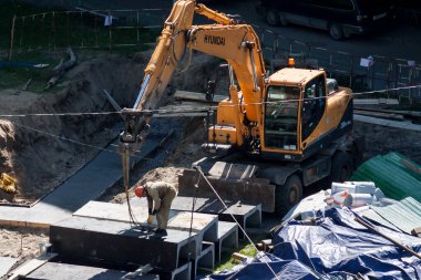 Tyumen, Rusya, 5 Haziran 2020: İnşaat. Çok katlı bir evin bahçesine su boruları döşemek..