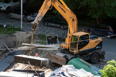 Tyumen, Rusya, 5 Haziran 2020: İnşaat. Çok katlı bir evin bahçesine su boruları döşemek..