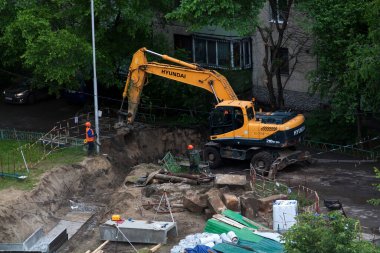 Tyumen, Rusya, 5 Haziran 2020: İnşaat. Çok katlı bir evin bahçesine su boruları döşemek..