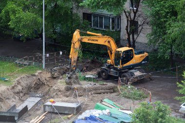 Tyumen, Rusya, 5 Haziran 2020: İnşaat. Çok katlı bir evin bahçesine su boruları döşemek..