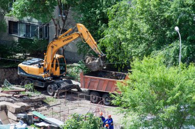 Tyumen, Rusya, 5 Haziran 2020: İnşaat. Çok katlı bir evin bahçesine su boruları döşemek..