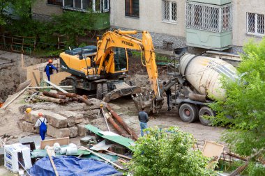 Tyumen, Rusya, 5 Haziran 2020: İnşaat. Çok katlı bir evin bahçesine su boruları döşemek..