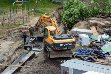 Tyumen, Rusya, 5 Haziran 2020: İnşaat. Çok katlı bir evin bahçesine su boruları döşemek..