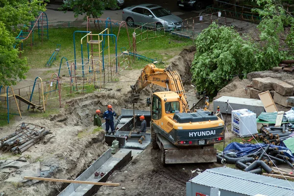 Tyumen, Rusya, 5 Haziran 2020: İnşaat. Çok katlı bir evin bahçesine su boruları döşemek..