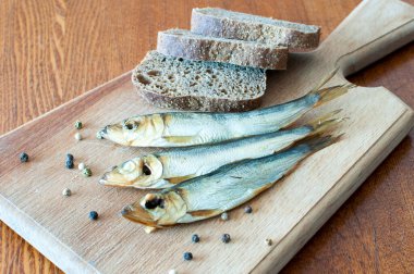 Tahta kesme tahtasındaki balık ve ekmekle hayat