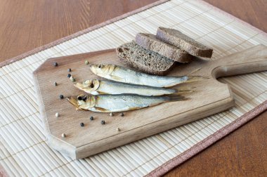Tahta kesme tahtasındaki balık ve ekmekle hayat