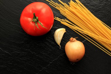 Spagetti, domates, soğan ve sarımsak kayrak kurulu, üstten görünüm